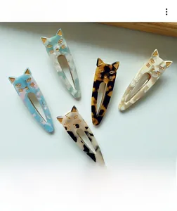 Detail view of acetate cat hair clips with tortoise shell pattern and gold trim edges