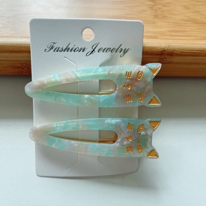 Close-up of cat-shaped acetate hair clips with marble texture on display card