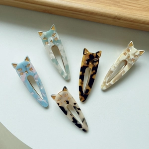 Close-up of five cute cat-shaped acetate hair clips in assorted marble textures and colors