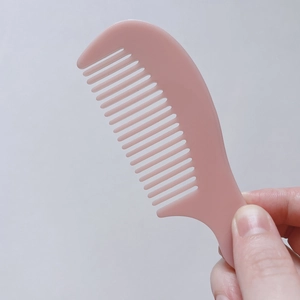 Detalle de un peine rosa Morandi de dientes anchos para un desenredado suave y eficaz