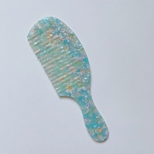 Macro detail of acetate hair comb featuring blue marble texture and smooth wide teeth