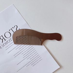 Detalle del mango ergonómico y las púas anchas de este peine para el cabello marrón carey
