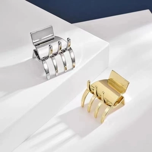 Polished gold and silver metal shark claw clips for high ponytail styling on pedestals
