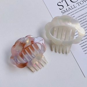 Close-up of wavy cloud acetate hair combs with iridescent marble texture and pearl finish