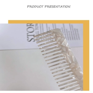 Détail du peigne en acétate marbré crème montrant les dents larges et la texture premium