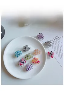Détails de petites pinces à cheveux à damier coloré posées sur un magazine d'art