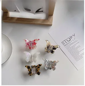 Flat lay of five acetate butterfly hair claws in various marble and floral patterns