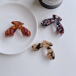 Three large tortoiseshell claw clips in leopard print and marble patterns for thick hair