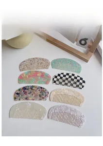 Detail of half-moon acetate hair combs showing marble, checkered and colorful patterns