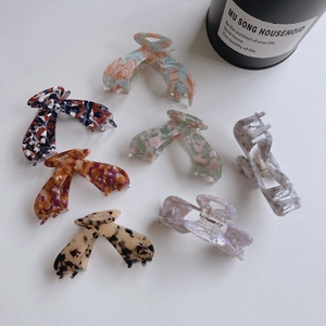 Various acetate claw clips featuring leopard print and marble patterns in a flat lay view