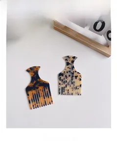 Detail view of acetate cellulose wide-tooth combs in marble and tortoiseshell patterns