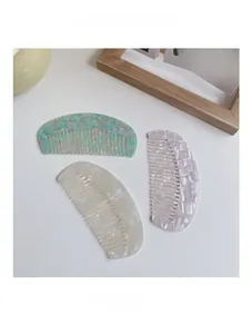 Detail of marble pattern acetate hair combs in mint green, pearl white, and purple