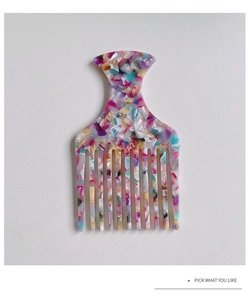Detailed view of acetate hair pick with colorful marble texture and fine teeth design