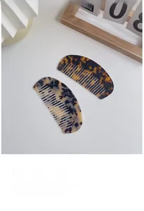 Macro detail of two tortoiseshell acetate hair combs with smooth polished finish