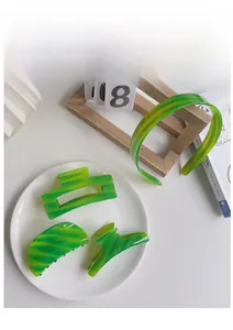Detail of green acetate hair claw clips and headband with elegant marble texture pattern