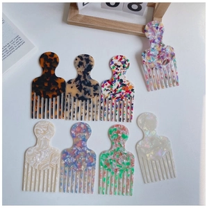 Flat lay of seven fine-tooth acetate hair combs with elegant marble and tortoiseshell patterns