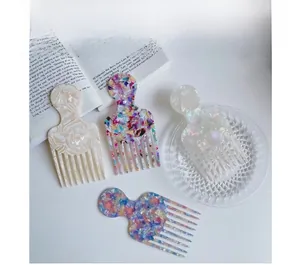 Detail showing four acetate hair combs with marble patterns on a white background