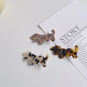 Detail of three acetate dog hair clips with leopard print and sparkling rhinestones