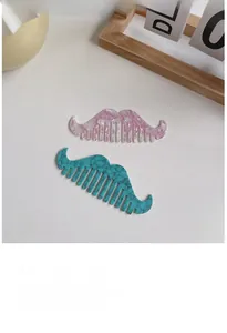 Detail of mustache shaped acetate hair combs in purple floral and green marble textures