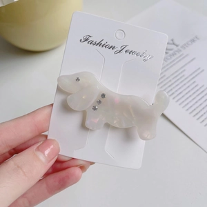 Close-up of a marble acetate dachshund dog hair clip with sparkling rhinestone details
