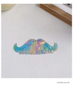 Detail view of mustache-shaped acetate hair comb with vibrant rainbow marble texture