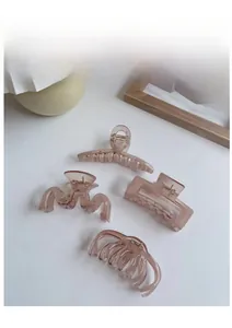 Detail view of four dusty pink resin hair claws in various elegant geometric shapes