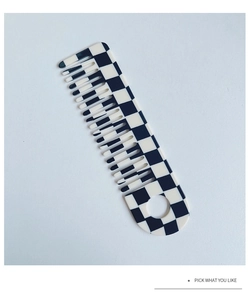 Detail view of black and white checkerboard acetate hair comb with a round hanging hole
