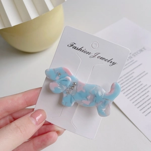 Close-up of blue marble dachshund hair clip with sparkling rhinestones on card