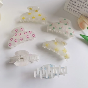 Floral and smiley face claw clips set in creamy acrylic for daily hair styling