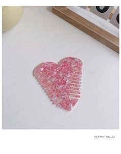 Detail view of heart-shaped acetate hair comb with elegant pink marble texture finish