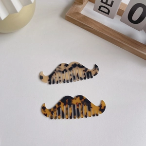 Set of two mustache-shaped acetate hair combs in classic tortoise shell patterns