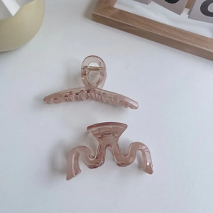 Elegant translucent amber pink hair claw clips in wavy and crossed minimalist designs