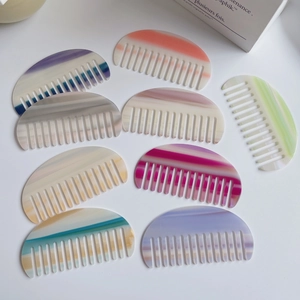 Vue détaillée de peignes en acétate aux couleurs marbrées variés sur un fond blanc épuré