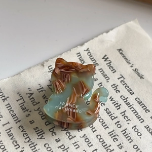 Detailed macro view of handmade acetate cat hair claw with vintage marble texture