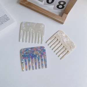 Three acetate hair combs with marble texture on white background with French style decor