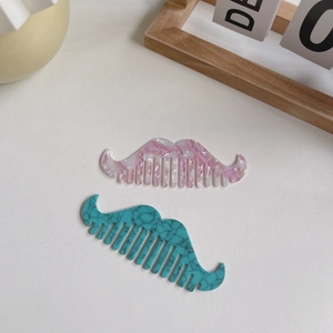 Pink and cyan acetate mustache-shaped hair combs with marble texture on neutral background