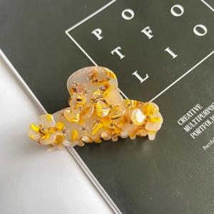 Detail of floral acetate hair claw clip with sparkling rhinestones and metal spring