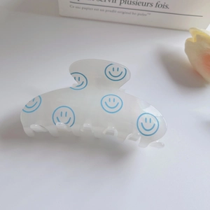 Translucent matte flower hair claw clip with blue smiley face pattern in 45-degree view