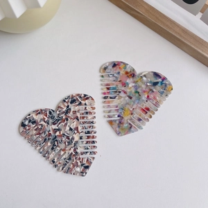 Fashion heart-shaped acetate hair combs set with colorful marble patterns on white background