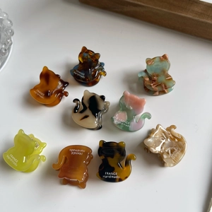 Mini cat-shaped acetate hair clips in various colors with elegant marble and tortoiseshell patterns