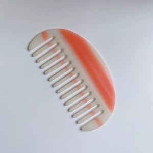 Peigne à cheveux demi-lune à motif marbré avec dents larges sur fond blanc pur