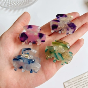 Set of 4 mini acetate hair claws in assorted colorful marble and tie-dye patterns