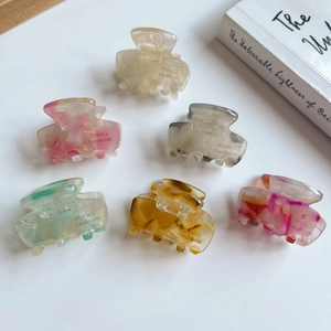 Set of 6 mini acetate hair claws in assorted marble and amber patterns on white background