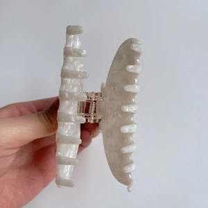 Detailed view of large marble texture acetate hair claw with high quality metal spring