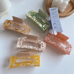 Detailed macro view of large acetate claw clips in various floral and marble patterns