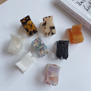 Eight small acetate hair claws in various patterns like tortoiseshell and marble