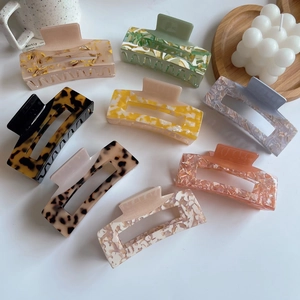 Macro detail of eight acetate hair claw clips with tortoiseshell and marble patterns