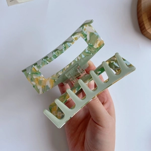 Detail of large square acetate hair claw clip with green marble texture and metal spring