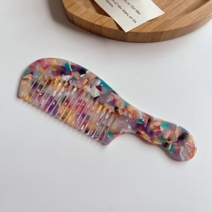 Détail d'un peigne à manche long avec texture marbrée en acétate de terrazzo coloré