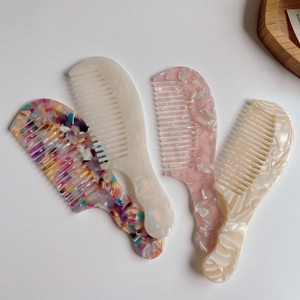 Lot de quatre peignes en acétate colorés à texture marbrée et manche ergonomique